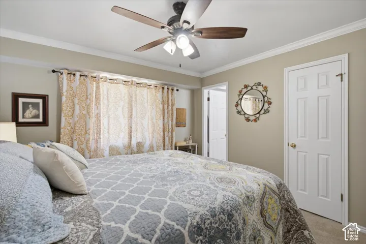 Bedroom featuring a ceiling fan with light fixture, crown molding, an oversized closet and en-suite bath. Mountain views from this room.