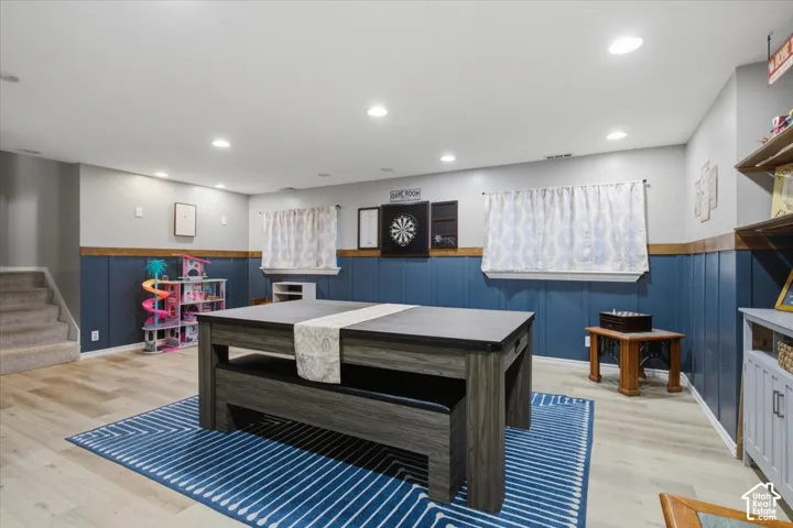 Spacious finished room featuring recessed lighting and wood-finish flooring