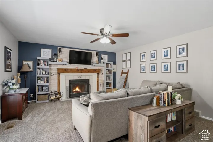Living area featuring a central fireplace with a rustic wood mantel and tile surround