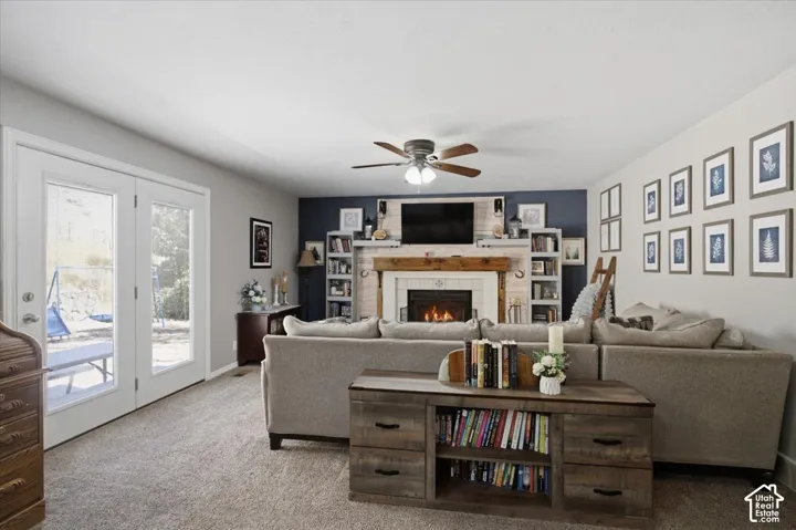Living area featuring a textured gray carpet and light gray walls, built in's around fireplace. Mountain views from door.