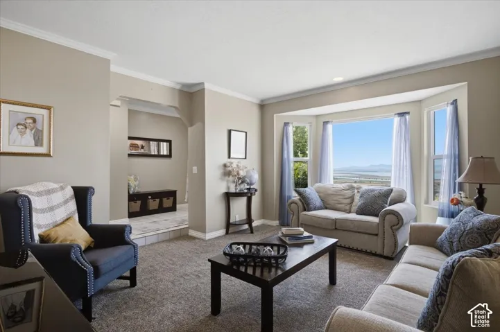 Living area featuring a spacious bay window with scenic valley and lake views, neutral wall tones, crown molding, and recessed lighting. Valley and lake views.