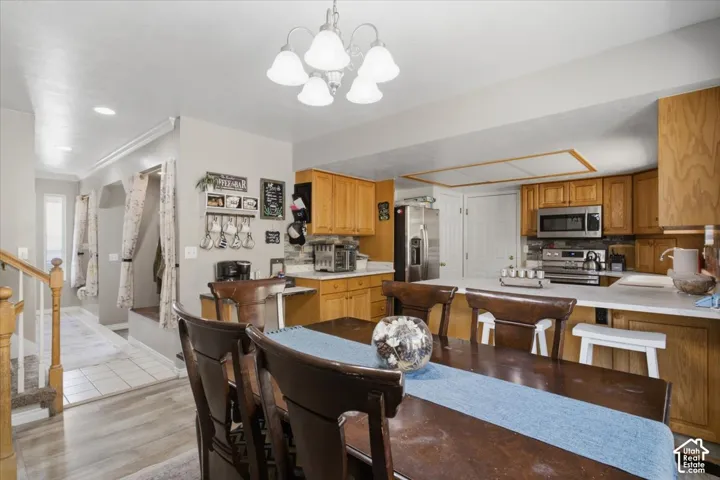 Dining area with a chandelier and wood-finish flooring