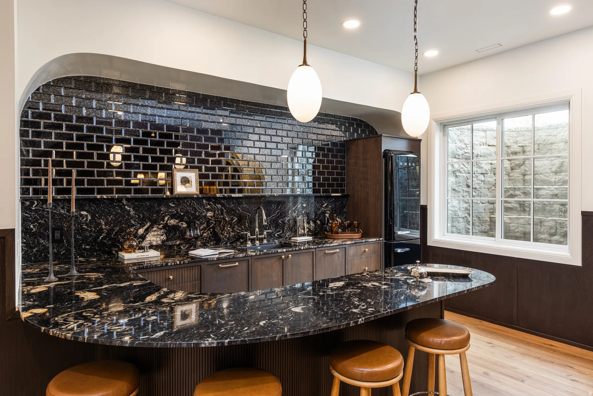 Curved bar featuring a dark granite countertop, dark wood-finish cabinetry, and a black subway tile backsplash
