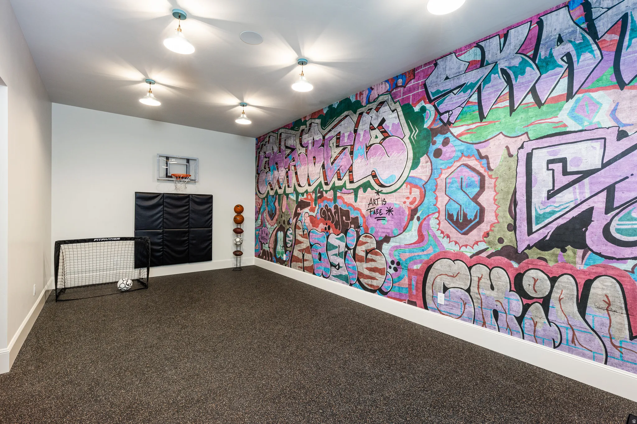 Spacious room featuring a vibrant graffiti-style accent wall