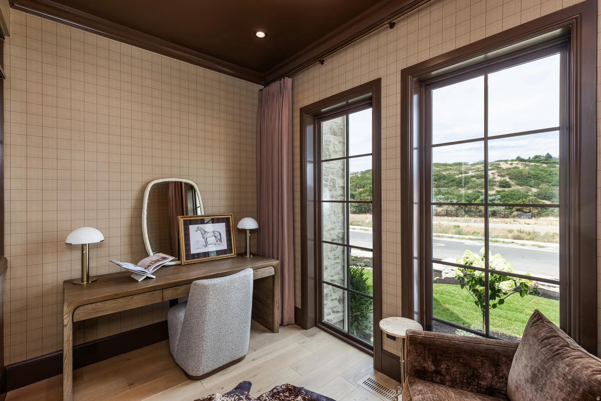 Room featuring light wood-finish flooring, patterned wall covering, dark trim, and a dark ceiling