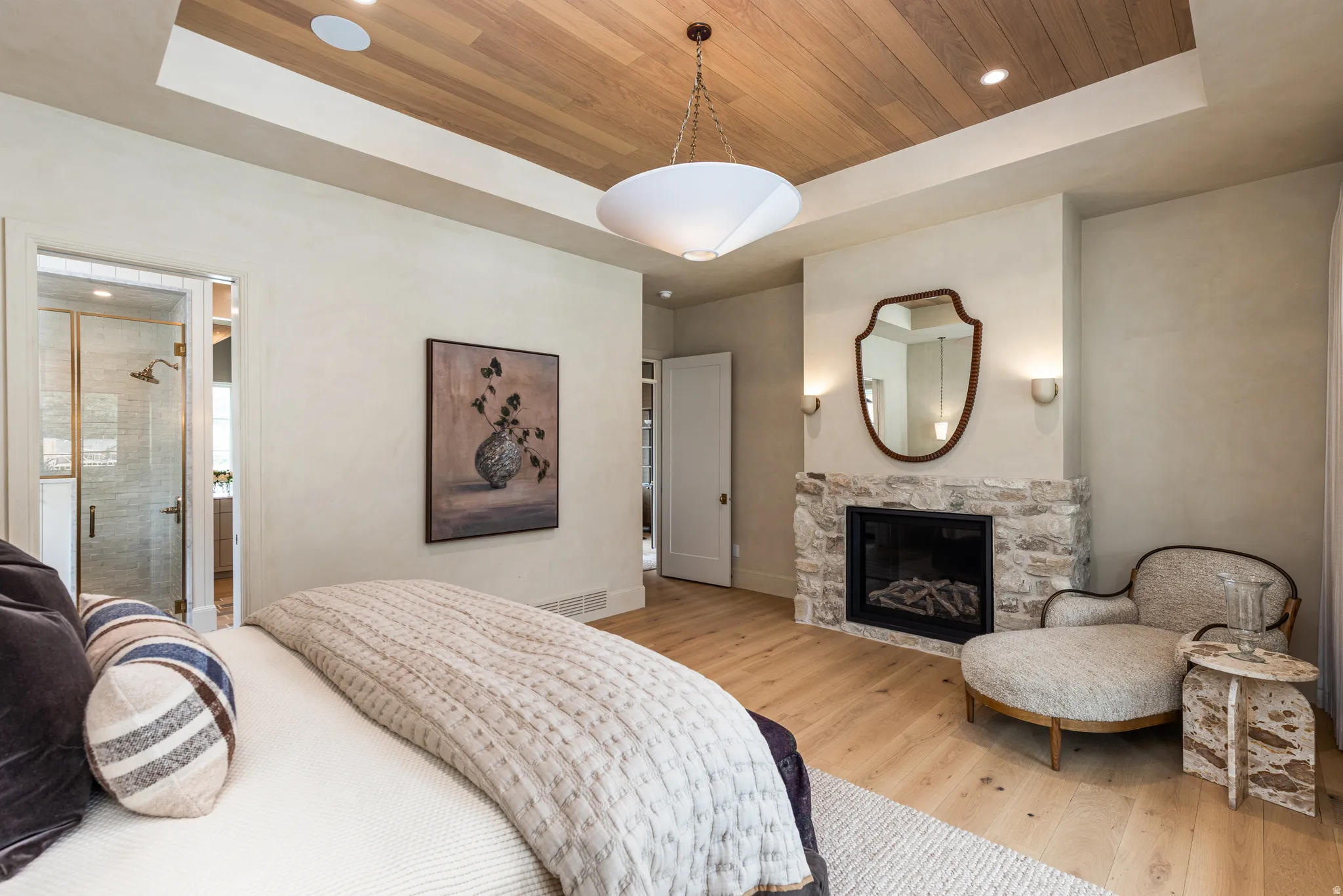 Spacious room featuring wood-finish flooring and a stone-clad fireplace