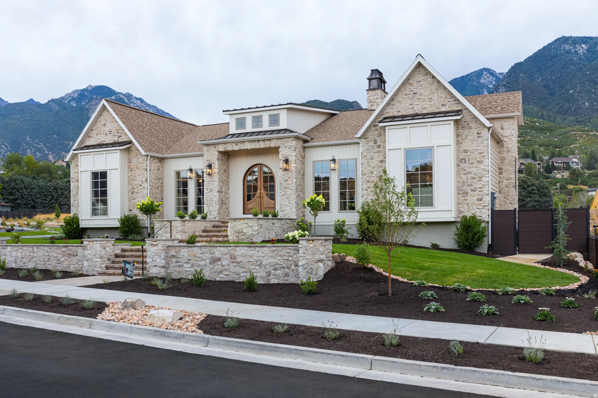 Stone and stucco exterior with a prominent arched wood entry door