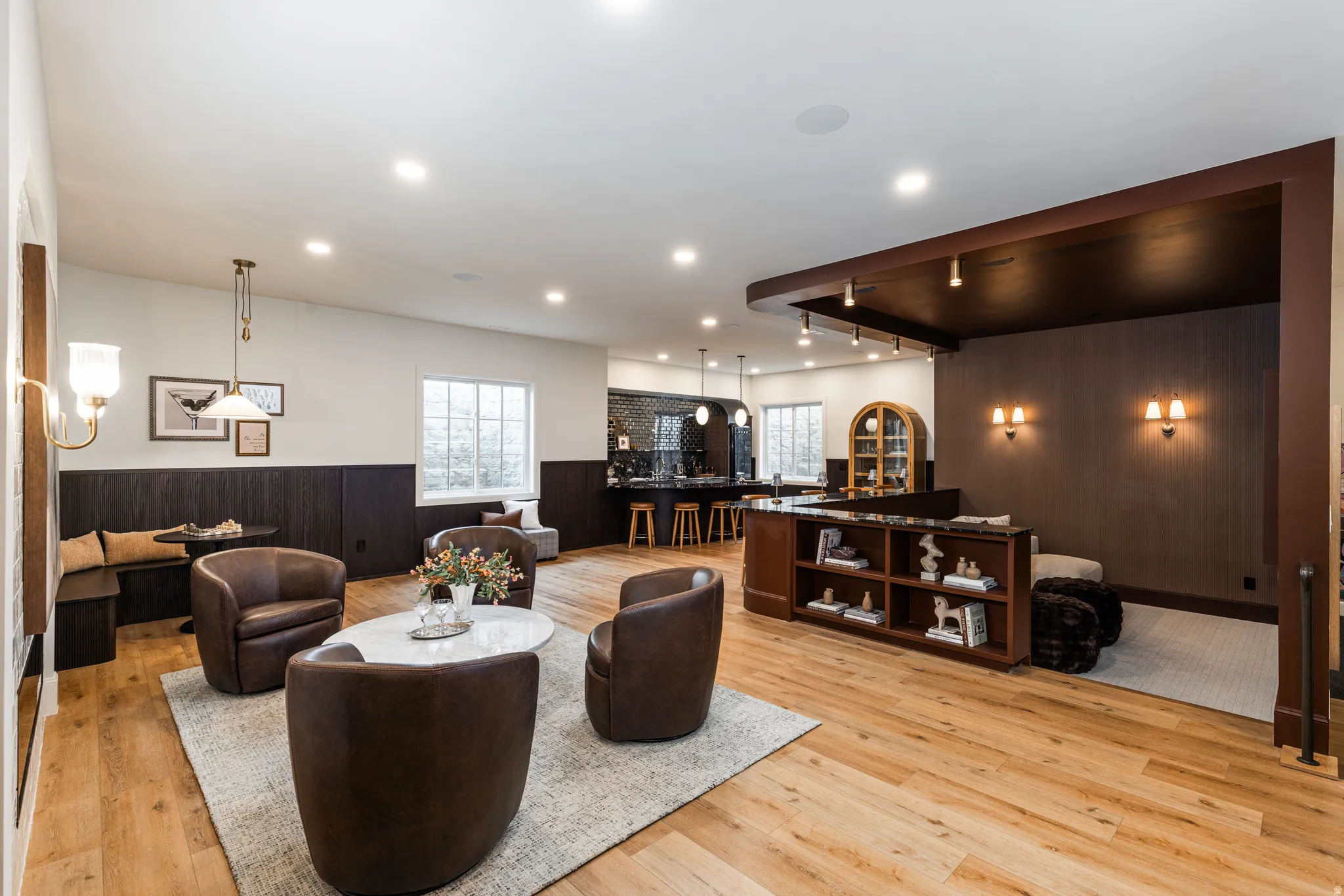 Spacious entertainment area featuring wood-finish flooring, recessed lighting, and a built-in media console