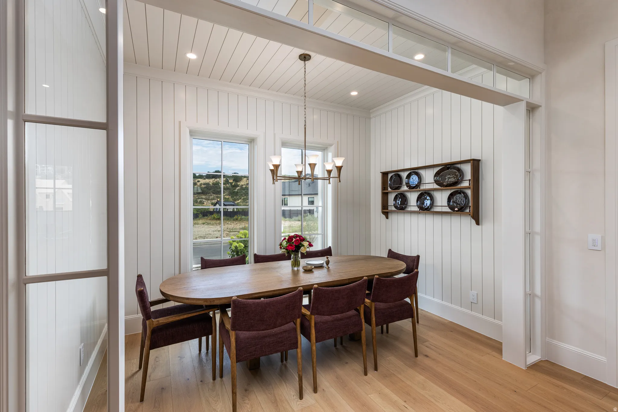 Dining space featuring light wood-finish flooring, white shiplap walls, and a white beadboard ceiling with recessed lighting