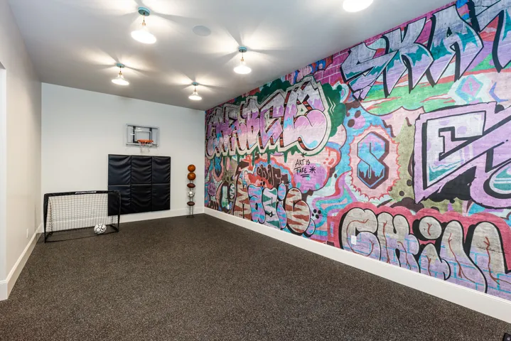 Spacious room featuring a vibrant graffiti-style accent wall