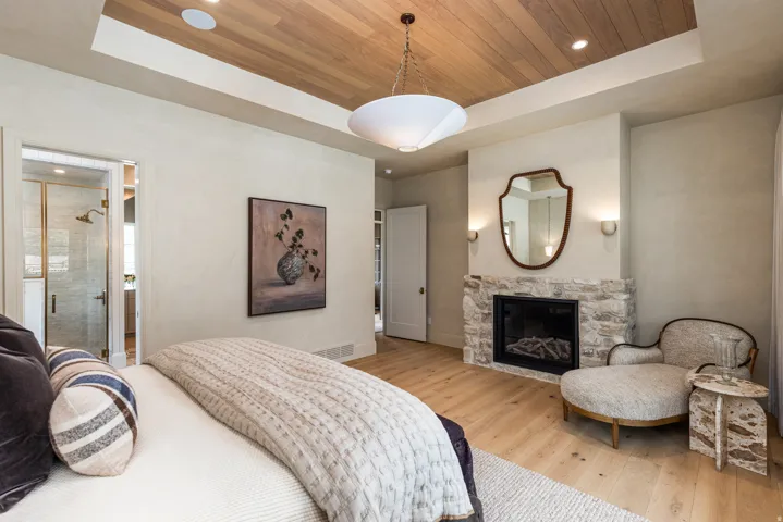 Spacious room featuring wood-finish flooring and a stone-clad fireplace