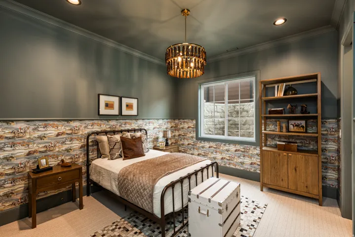 Recessed lighting and a distinctive brass chandelier illuminate this room featuring a window with a stone-textured exterior view