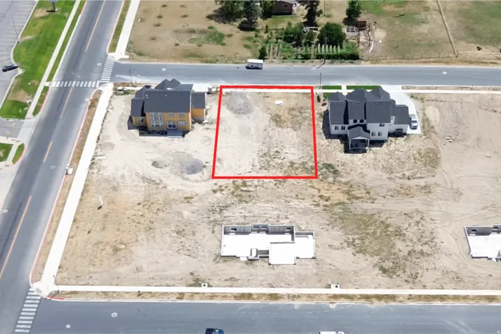Cleared residential lot with established street infrastructure and sidewalk