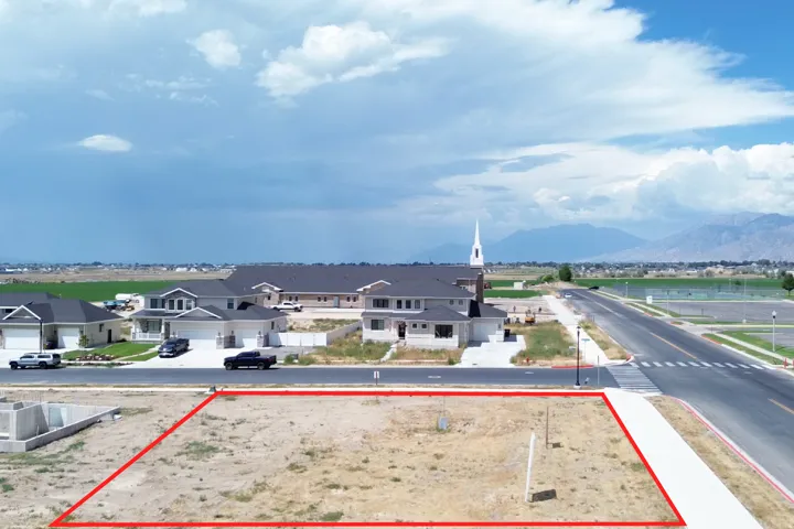 Vacant lot featuring a level terrain, paved street frontage, and a concrete sidewalk
