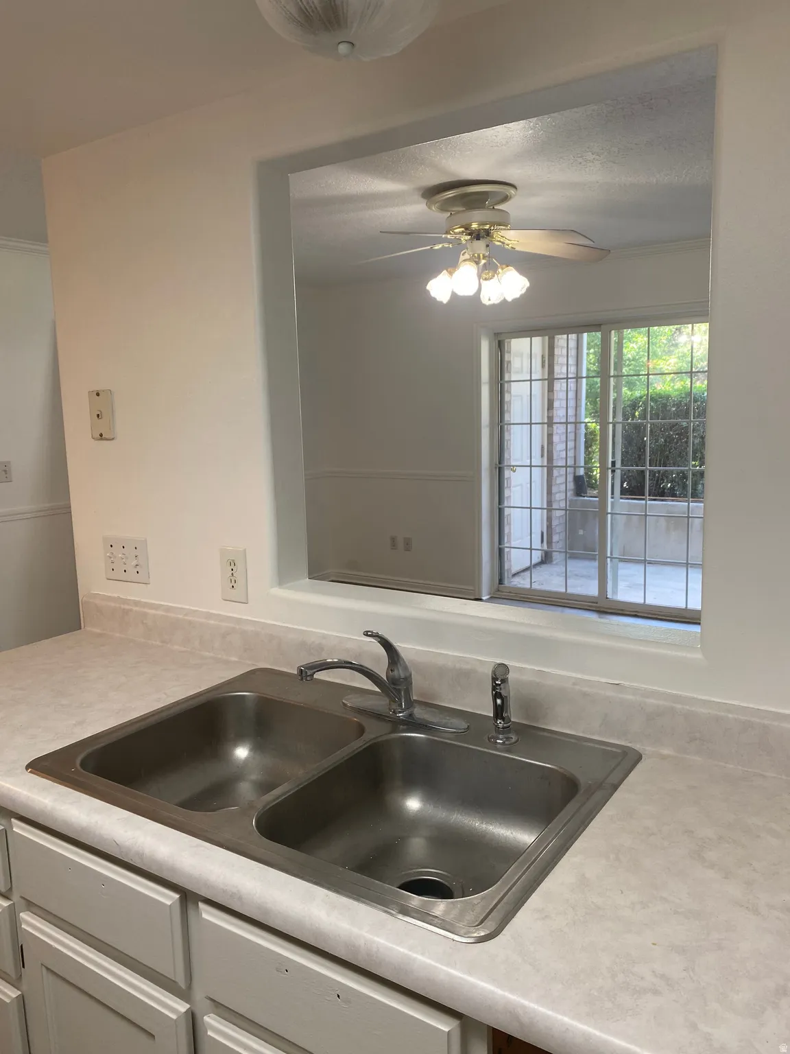 Kitchen sink area featuring a dual-basin stainless steel sink with a chrome faucet