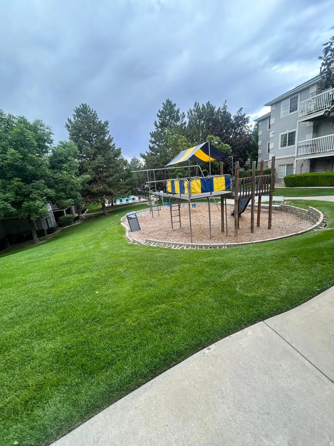Community playground featuring a slide, climbing elements, and a shaded platform