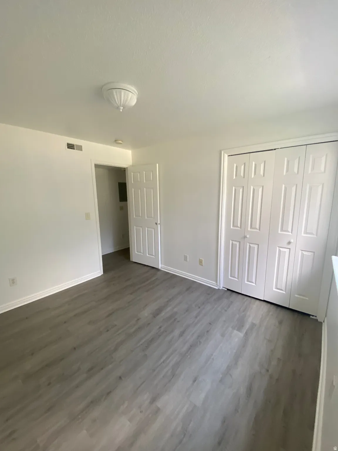 Room featuring light wood-finish flooring, white painted walls, and white baseboards