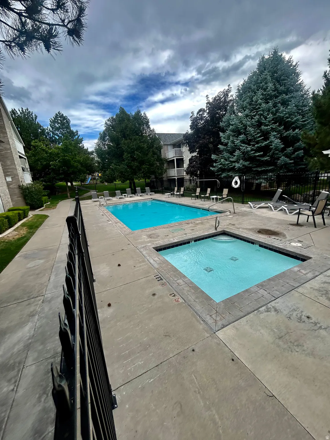 Outdoor amenity area featuring a rectangular swimming pool and an adjacent square spa