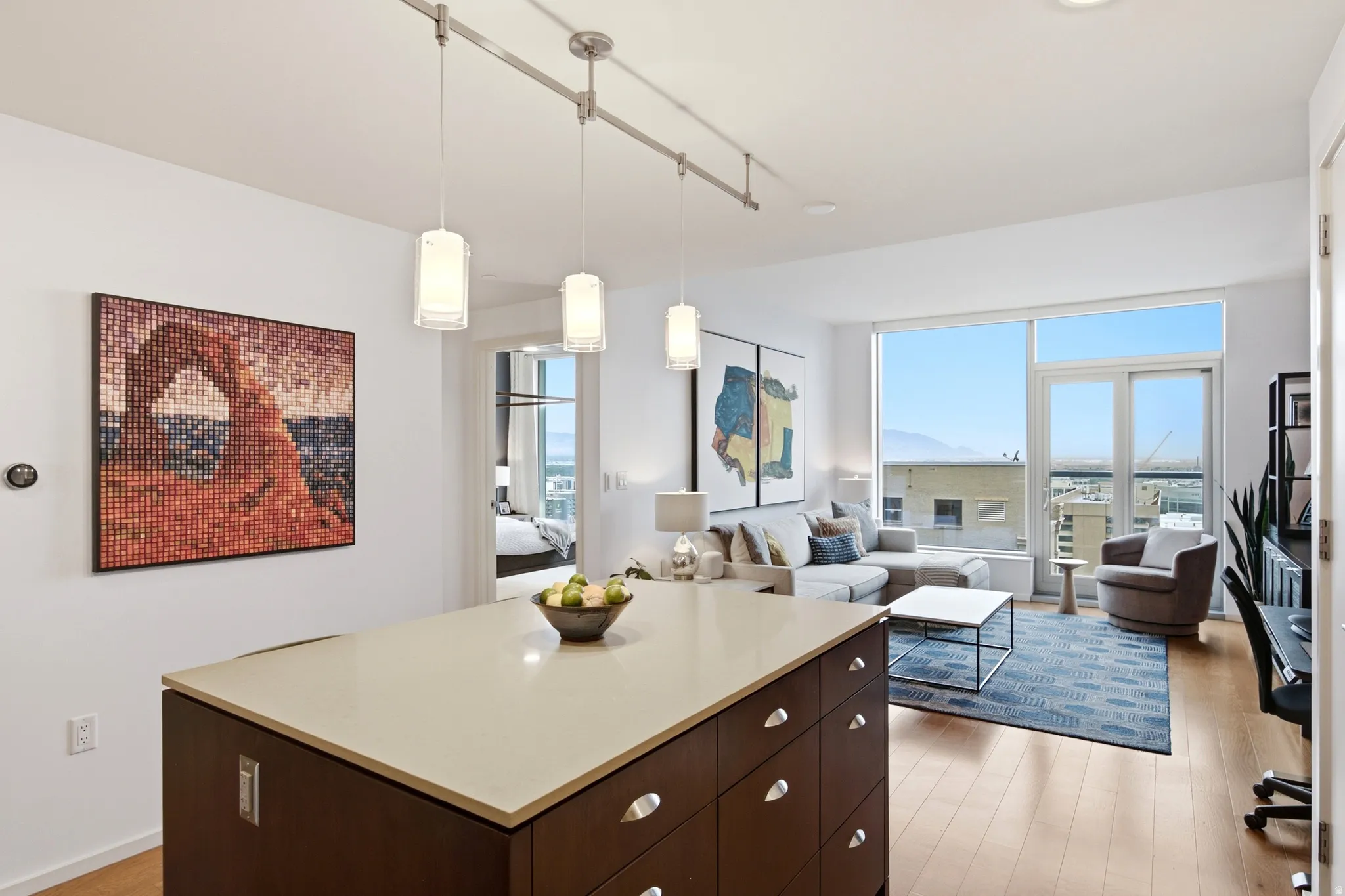 Open-concept living space with large windows and light wood-finish flooring