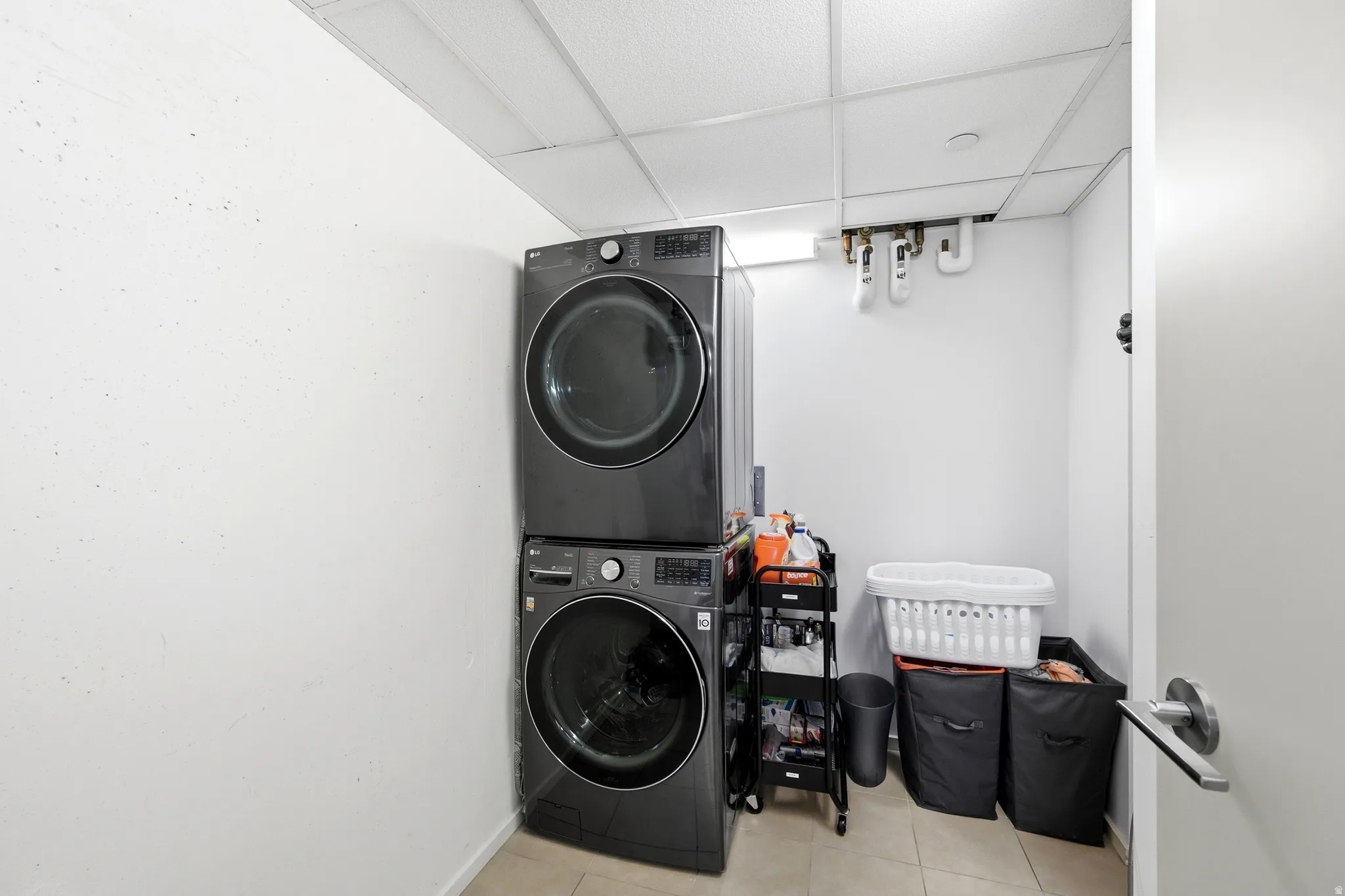 Dedicated laundry space featuring a stacked washer and dryer unit