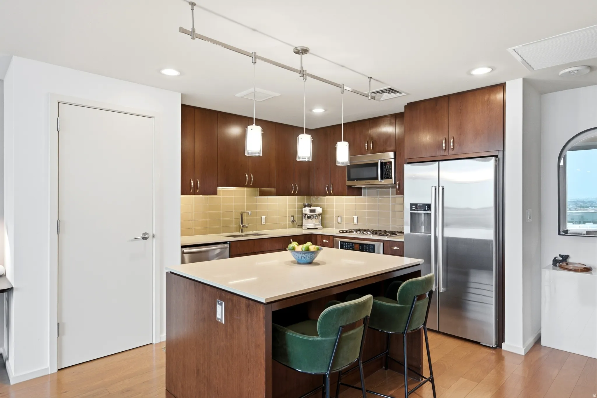 Kitchen featuring a central island, rich wood-finish cabinetry, stainless steel appliances, and wood-finish flooring