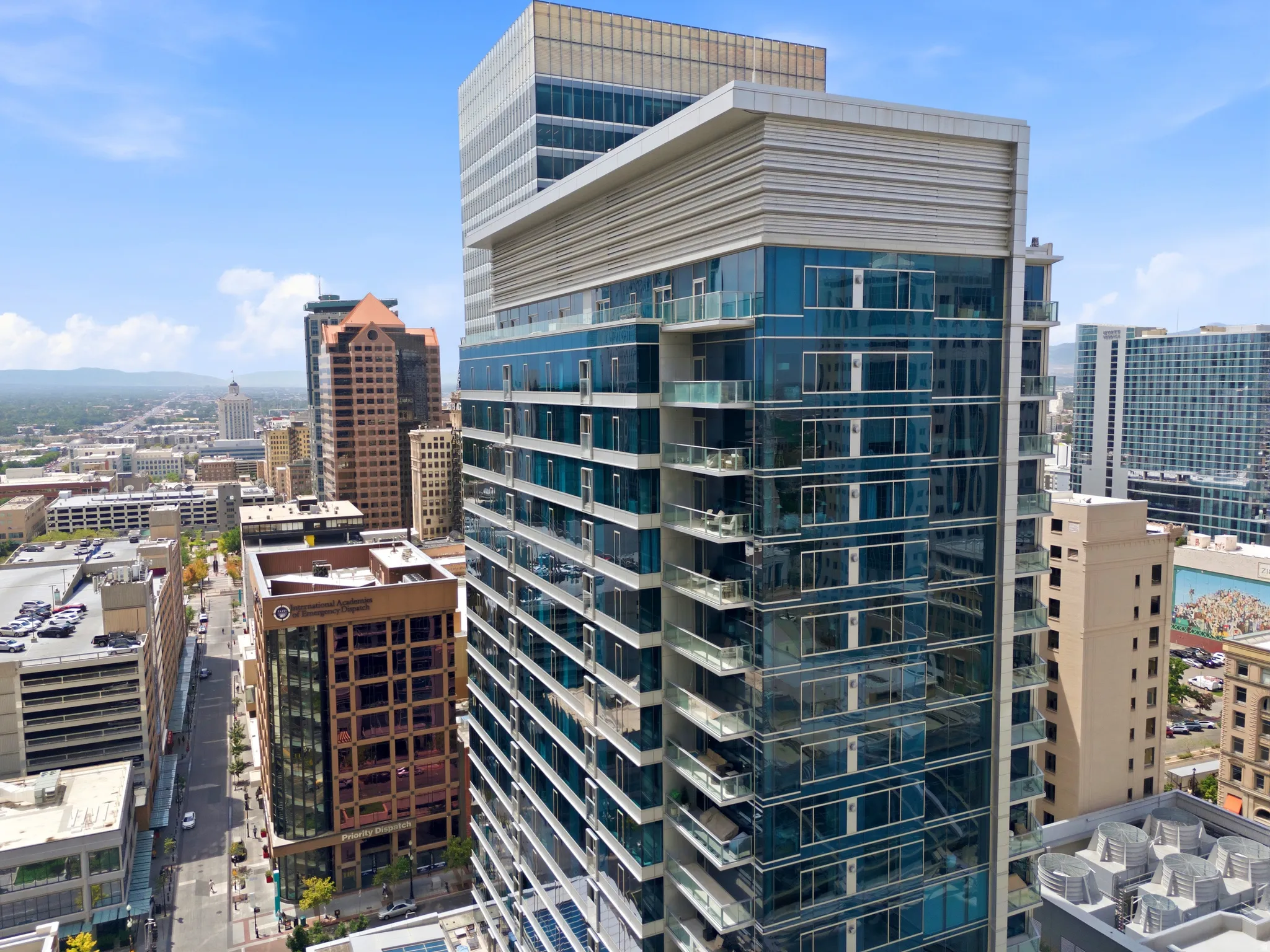 Modern high-rise residential building featuring a multi-story glass facade and private balconies