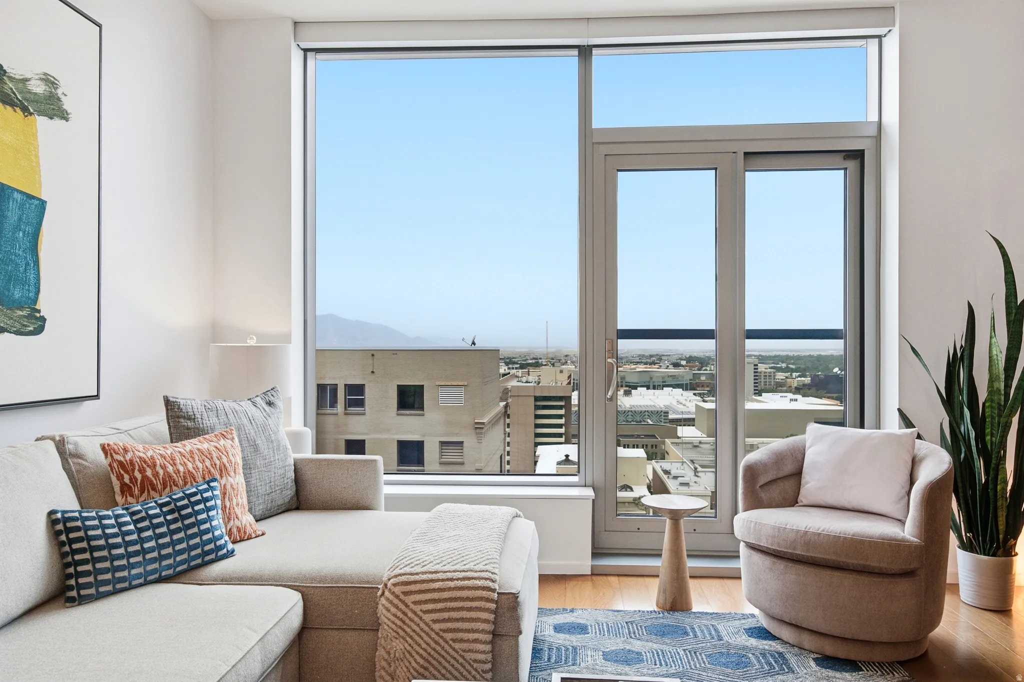 Floor-to-ceiling windows and a glass door provide abundant natural light