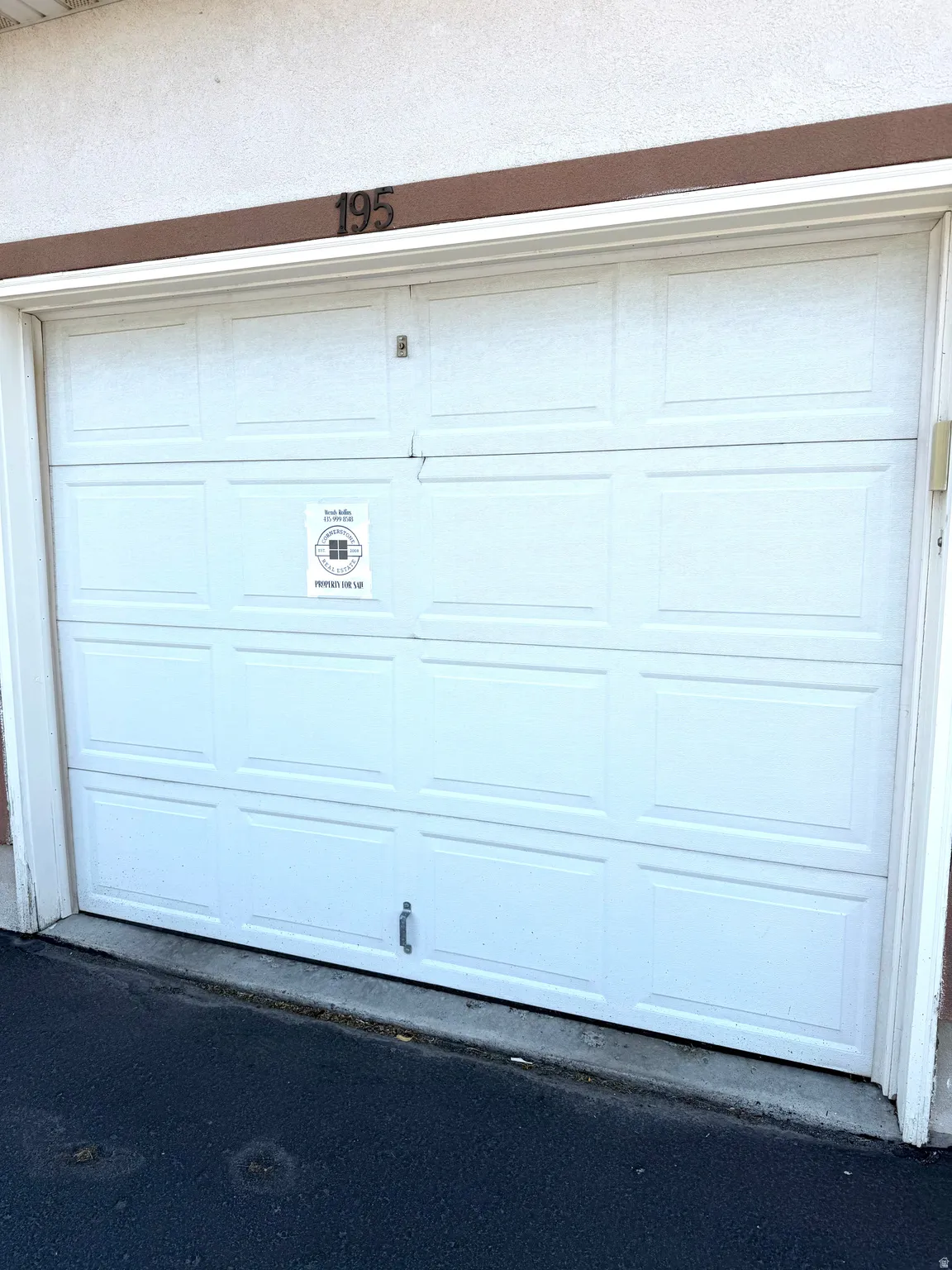 White panel garage door with address numbers 195