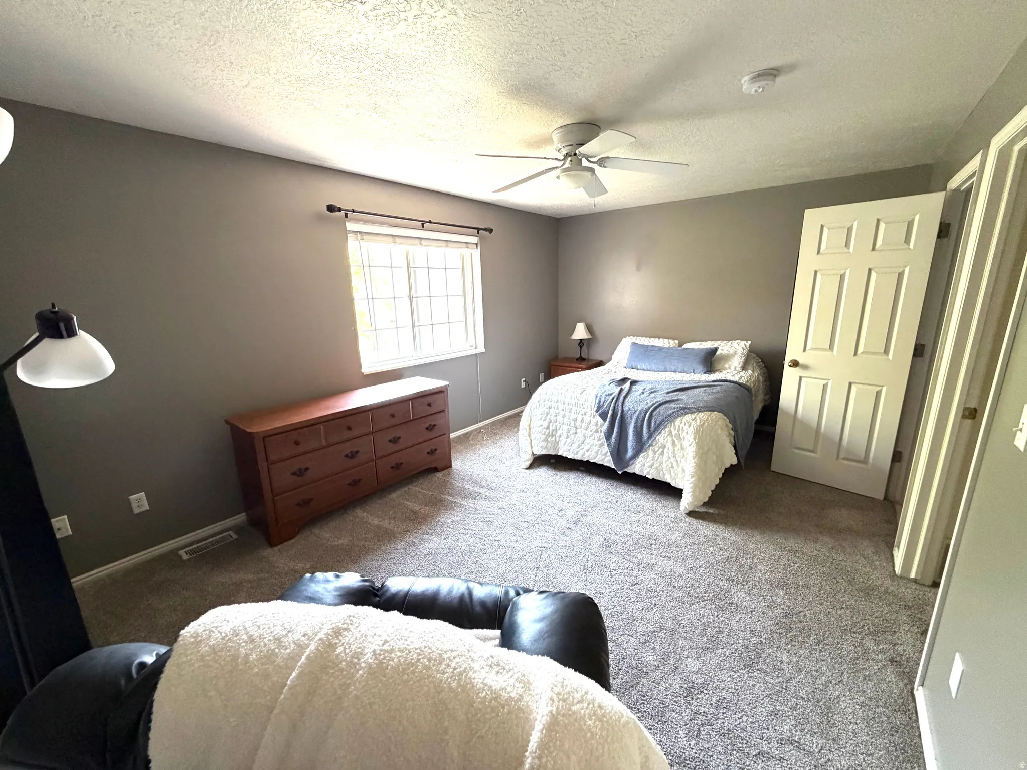 Carpeted room featuring neutral wall tones and a window with blinds