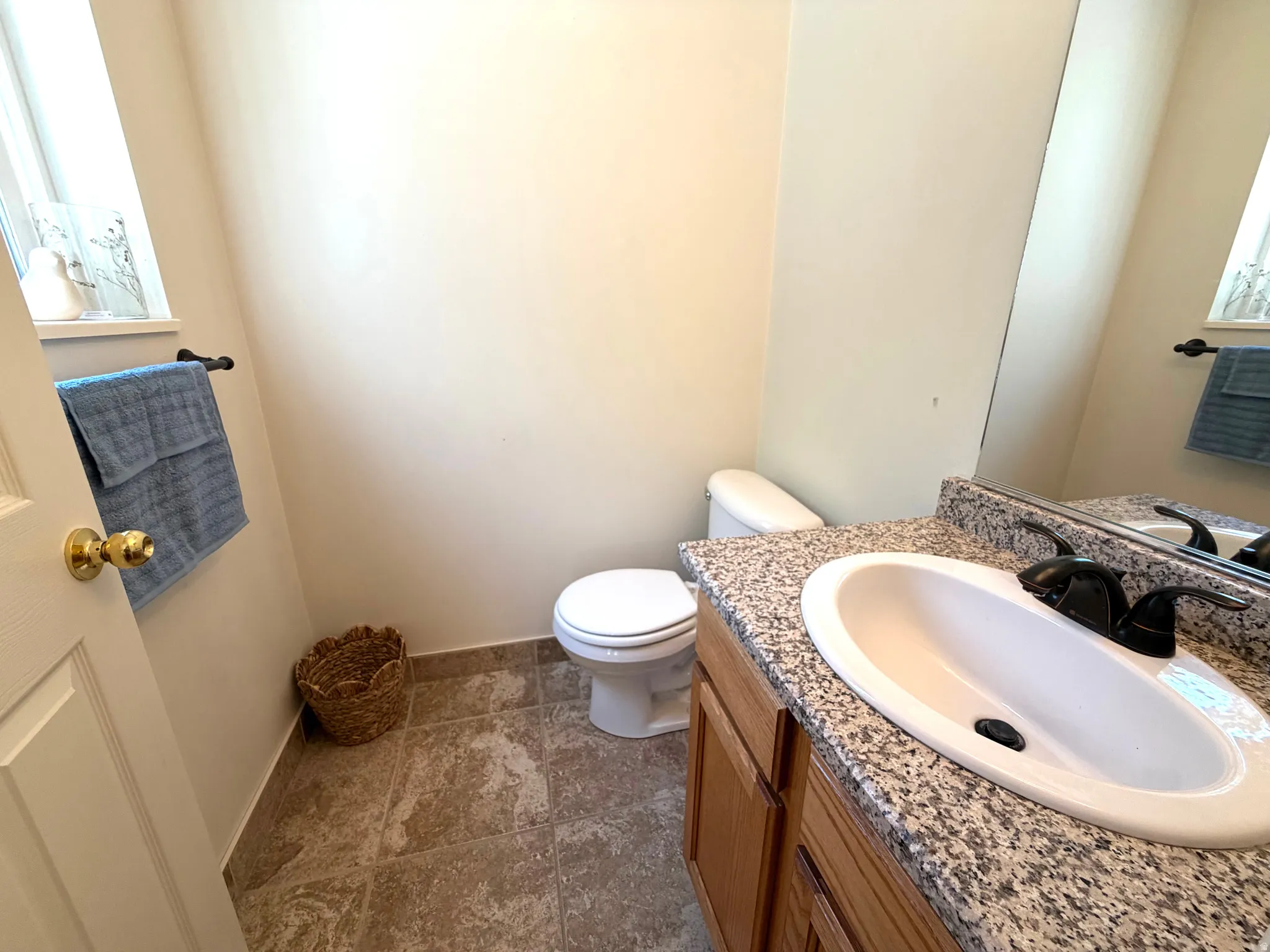 Bathroom featuring a granite-look countertop, integrated white sink, and dark bronze faucet