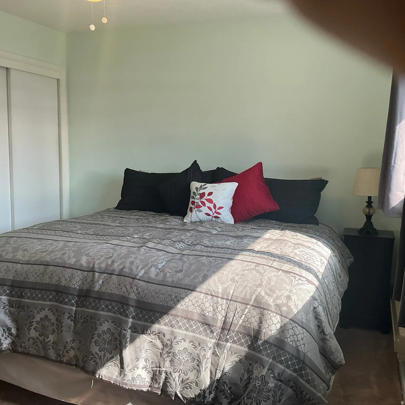 Spacious room featuring light green walls and carpet flooring