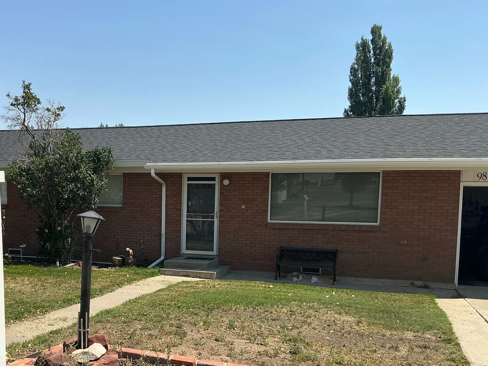 Brick exterior with a dark shingle roof and white gutters