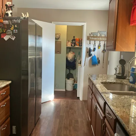 Kitchen featuring wood-finish flooring, granite countertops, and wood cabinetry