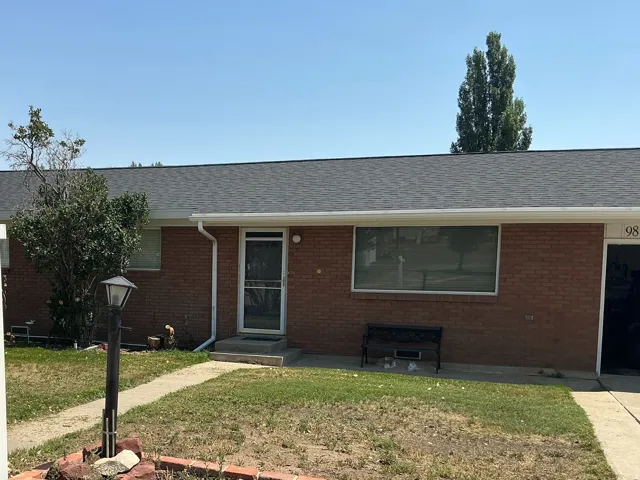Brick exterior with a dark shingle roof and white gutters