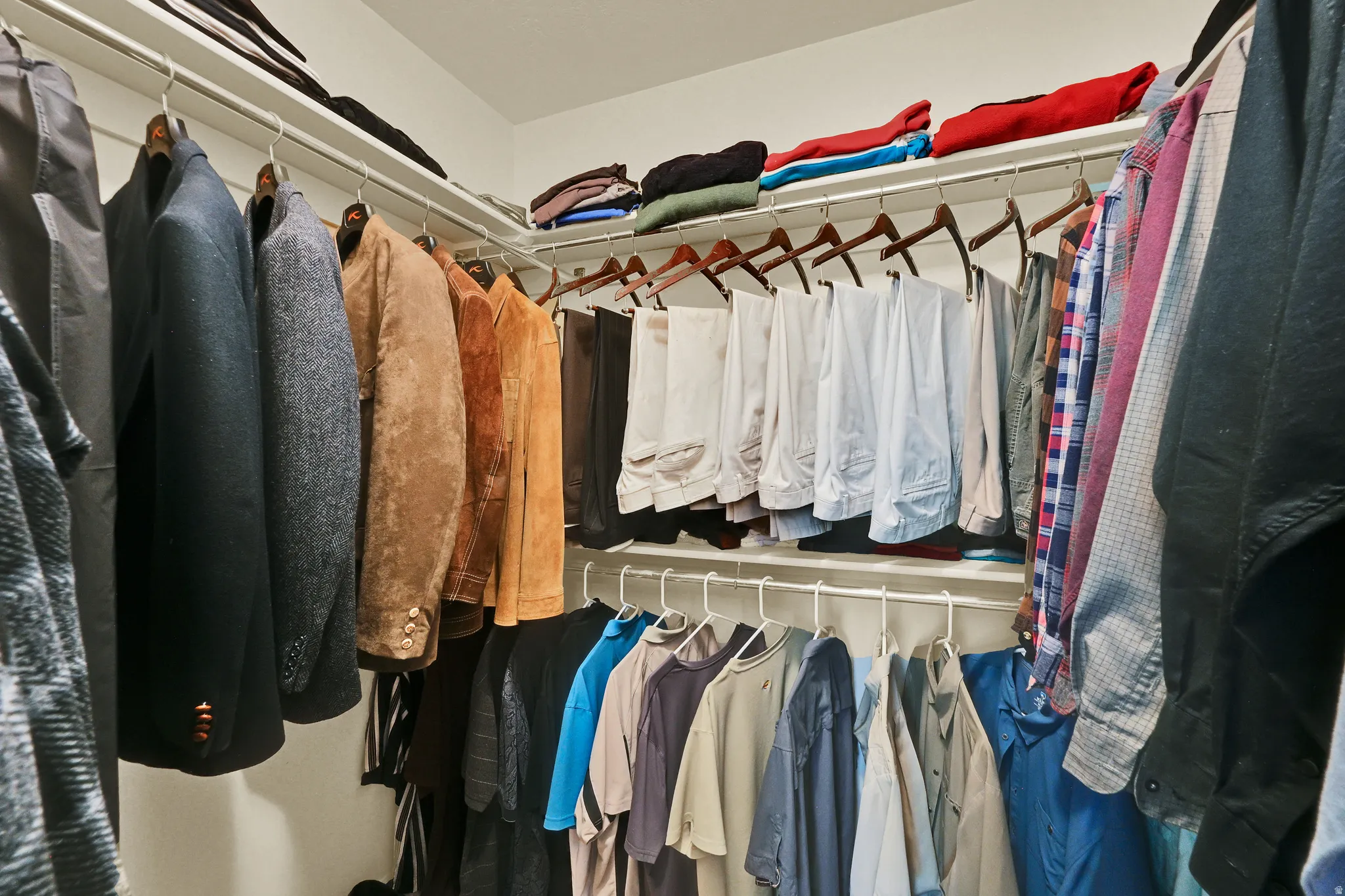Walk-in closet with multi-level shelving and hanging rods