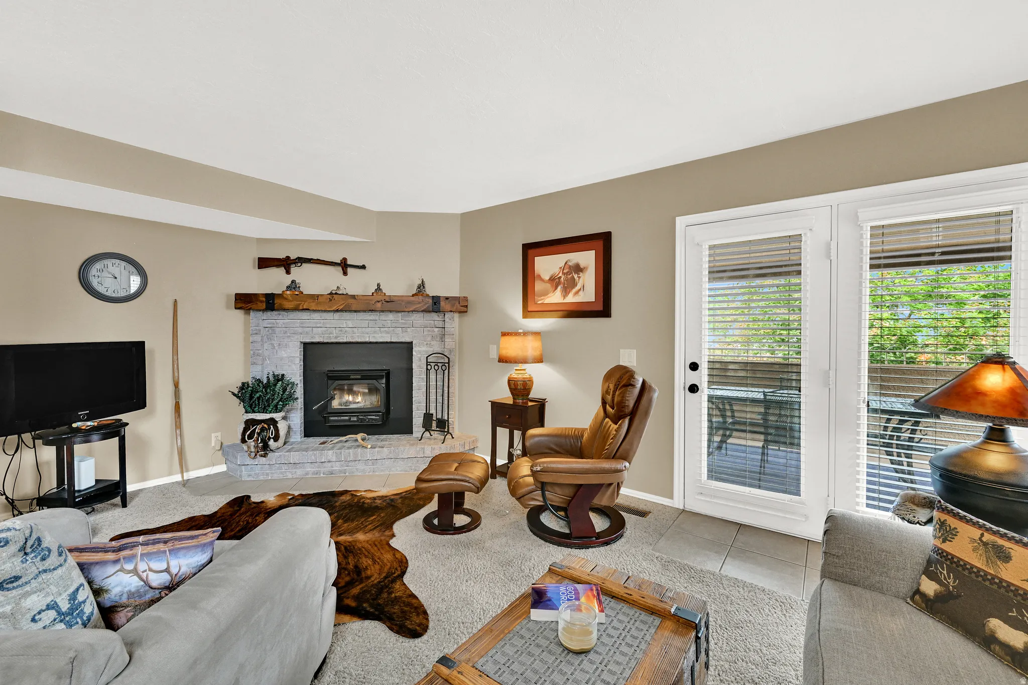 Living area featuring a stone fireplace with a wood mantle, carpet flooring, and neutral wall paint