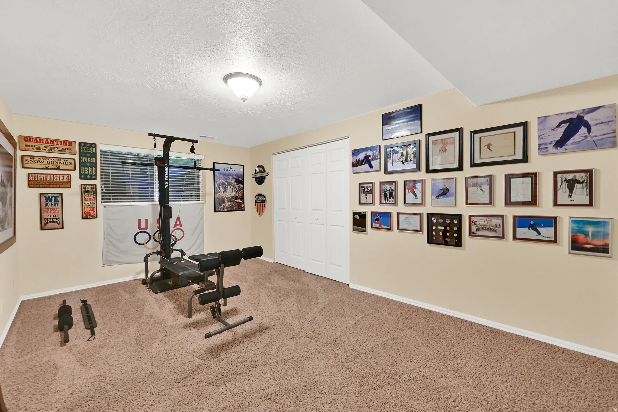 Spacious room featuring neutral carpeting, light-colored walls, and a white bi-fold closet door