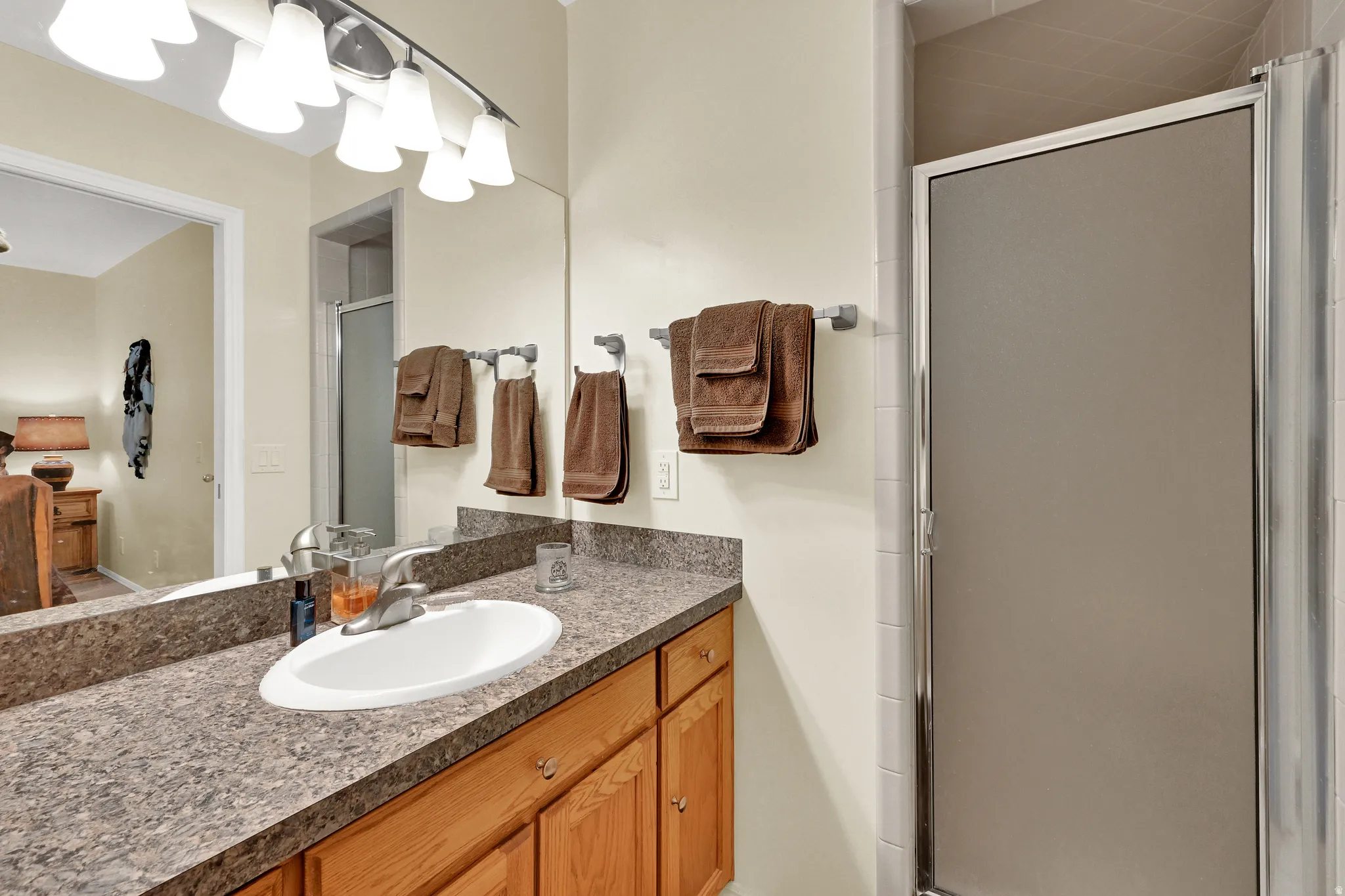 Bathroom vanity featuring a speckled countertop, a single basin sink, and wood cabinetry