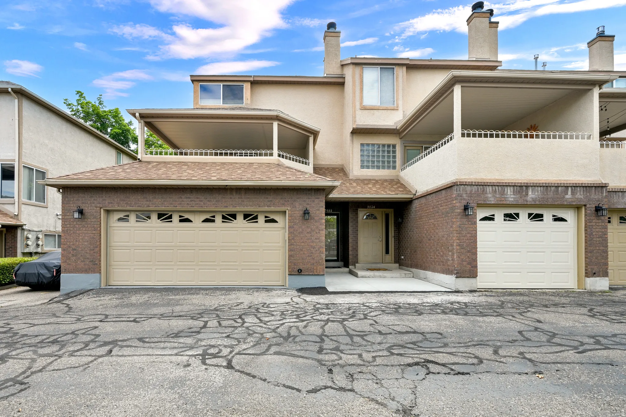 Townhome exterior featuring a combination of brick and stucco finishes
