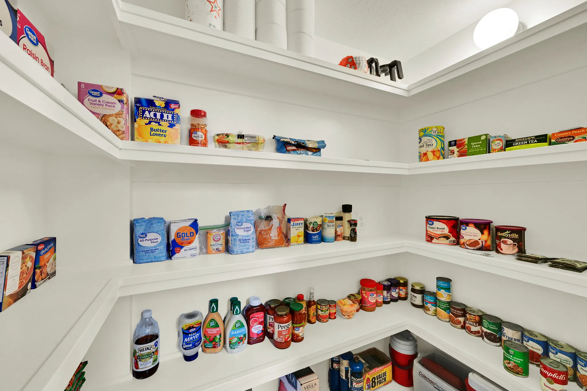 Corner pantry featuring multiple white shelves for ample storage