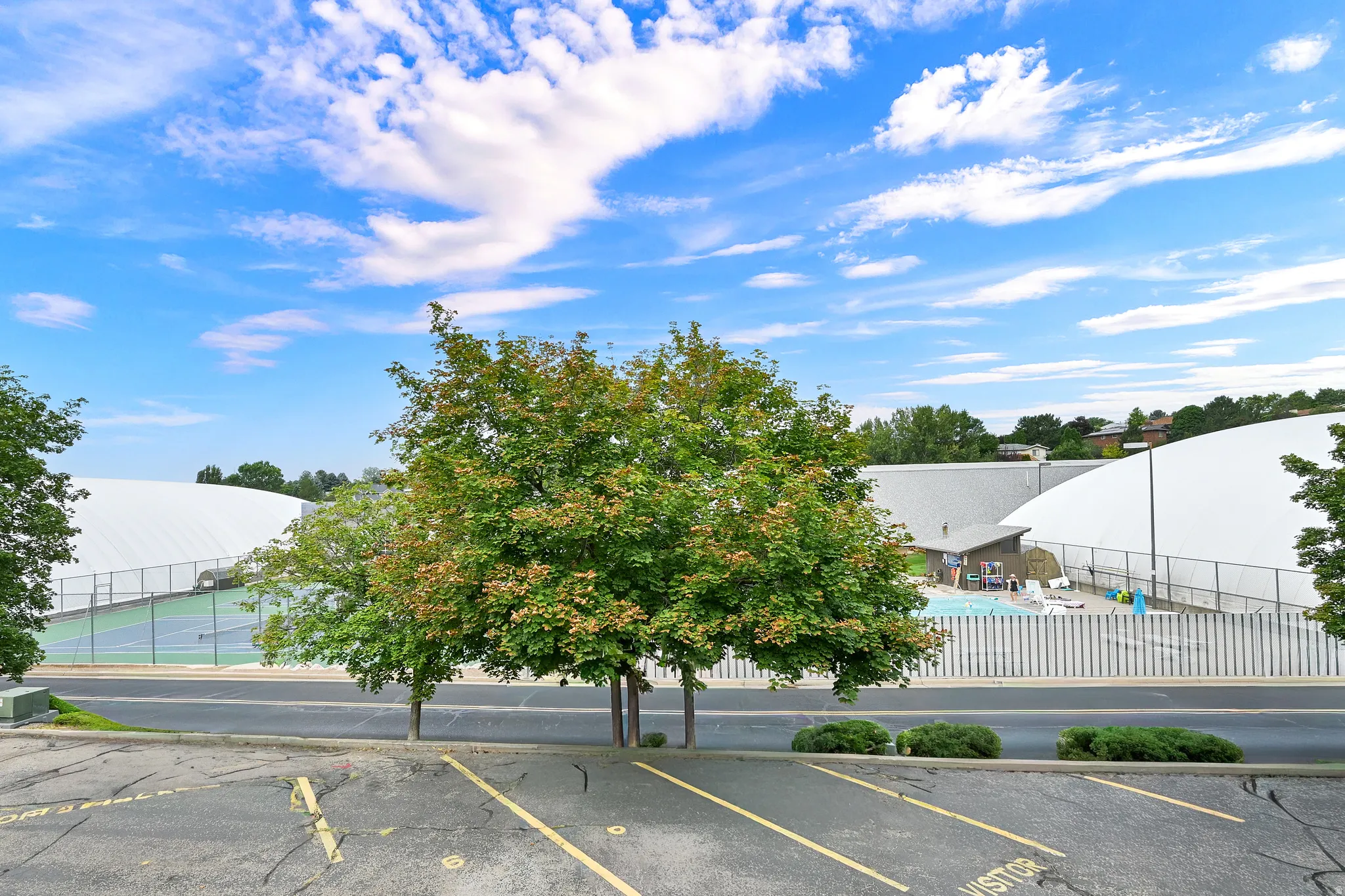 Outdoor amenities featuring a swimming pool, tennis courts, and large white dome structures
