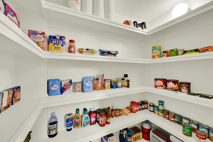 Corner pantry featuring multiple white shelves for ample storage