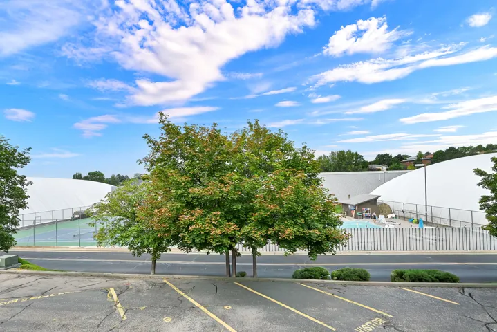 Outdoor amenities featuring a swimming pool, tennis courts, and large white dome structures