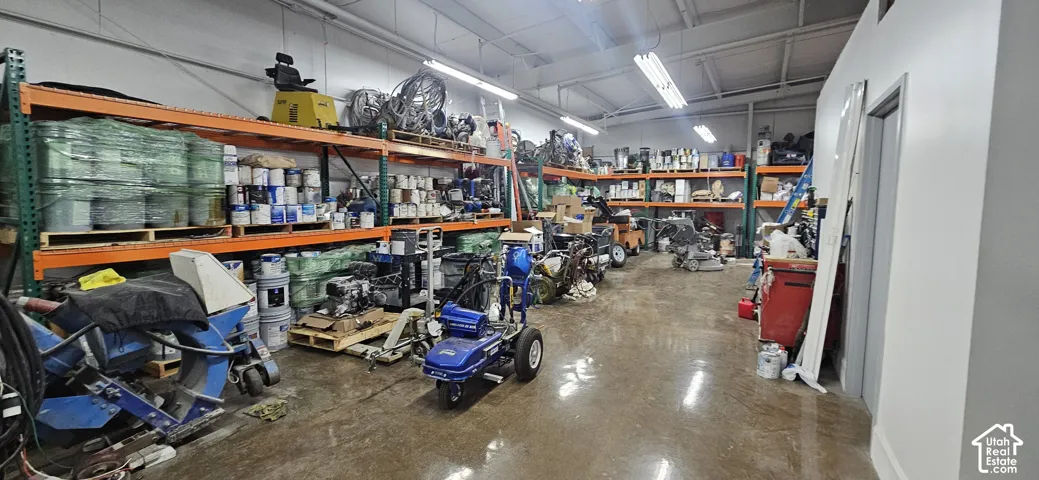 Expansive interior warehouse space featuring high ceilings, concrete flooring, and extensive industrial shelving for storage