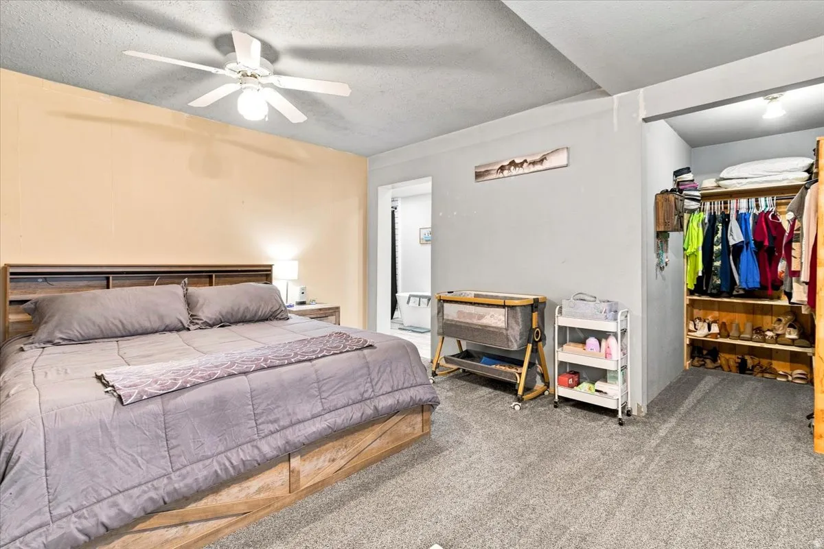 Bedroom featuring light-toned walls, a ceiling fan, and carpet flooring