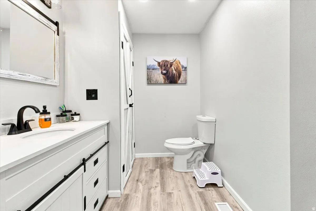Contemporary bathroom vanity featuring a white countertop with an integrated sink and matte black faucet
