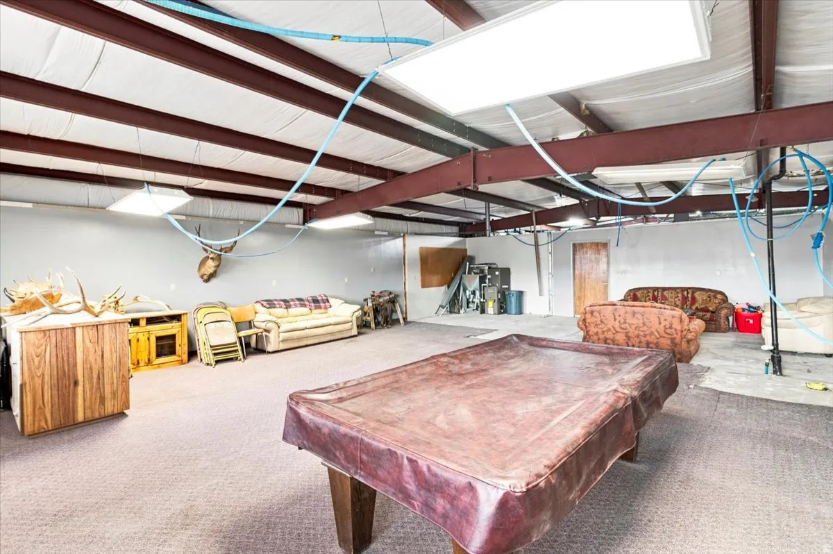 Spacious interior with exposed steel beams, industrial ceiling panels, and recessed lighting