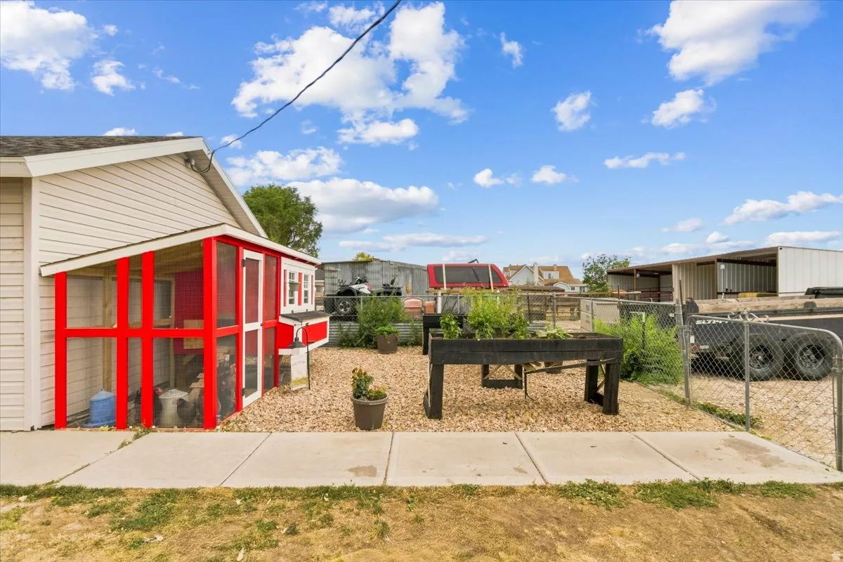 Exterior with light-colored siding and a red outbuilding featuring screened enclosures
