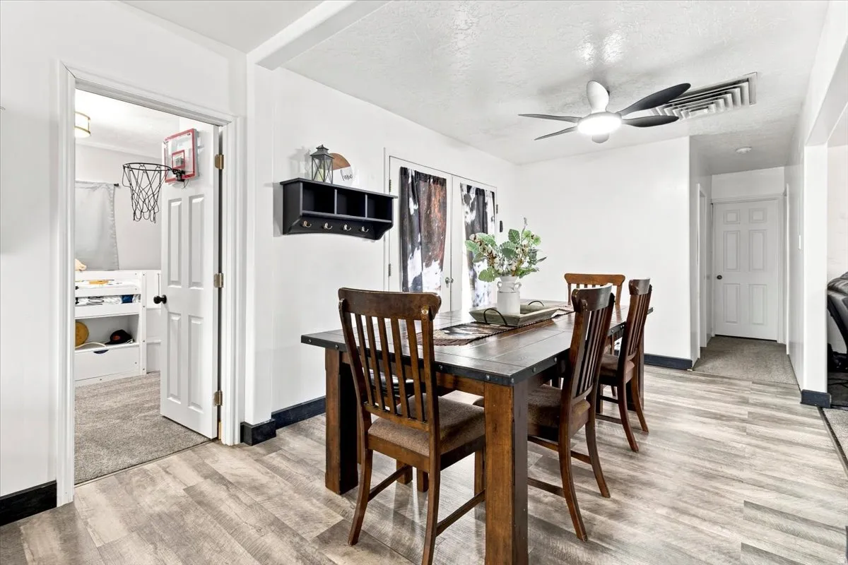Dining area featuring wood-finish flooring and a contemporary ceiling fan with integrated lighting