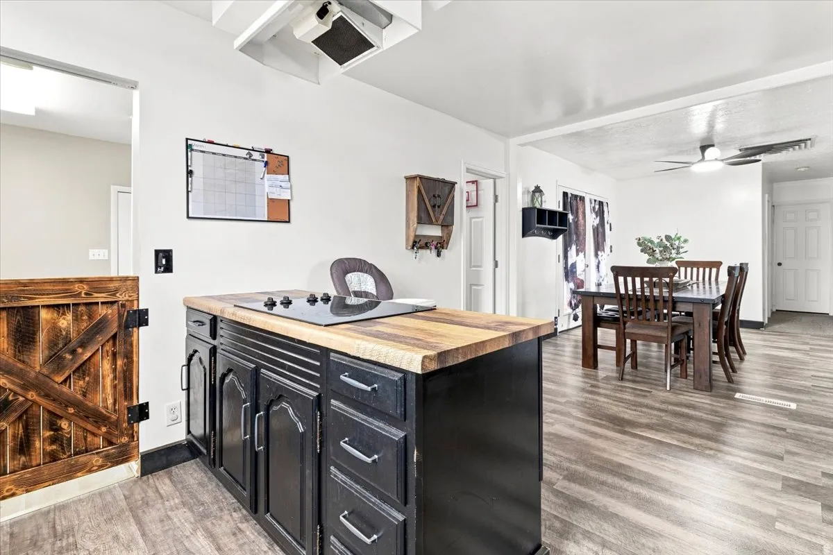 Kitchen island featuring a wood-finish countertop and black cabinetry with silver-tone pulls